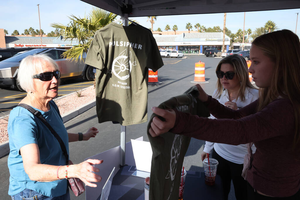 Candice Leigh, left, buys a T-shirt honoring Metropolitan Police Department officer Colton Puls ...