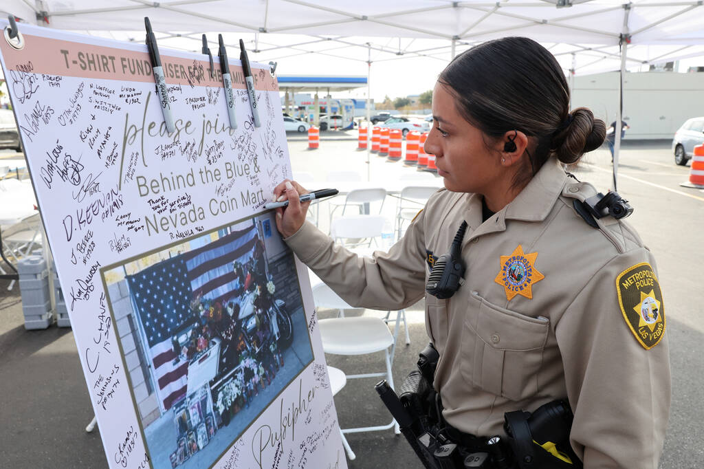 Las Vegas police officer Jazmin Valenzuela signs a banner honoring Metropolitan Police Departme ...