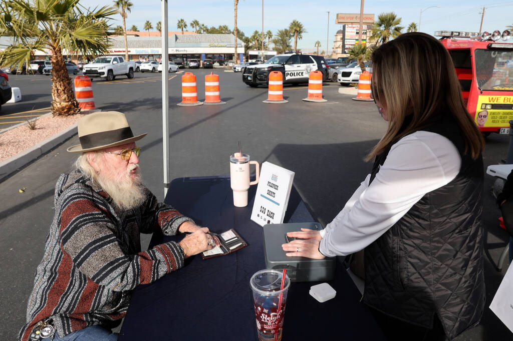 Donald Lane writes a check to make a donation and buy a T-shirt honoring Metropolitan Police De ...