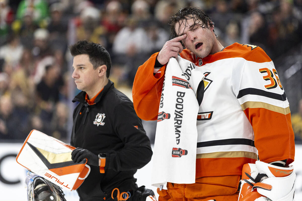 Anaheim Ducks goaltender John Gibson (36) is helped off the ice after taking a stick through hi ...