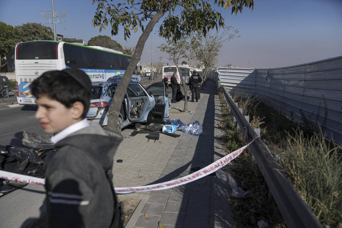 Israel's security officers check a damaged car at the site of an attack in east Jerusalem neigh ...