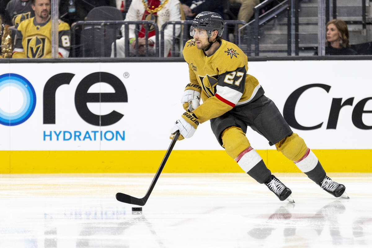 Golden Knights defenseman Shea Theodore (27) controls the puck during the NHL hockey game again ...