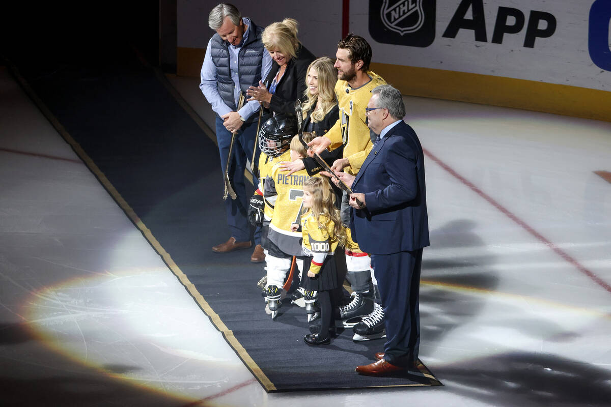 Vegas Golden Knights defenseman Alex Pietrangelo (7) is presented with a golden hockey stick ho ...