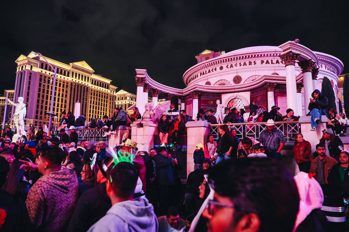 Crowds of people line the Strip in front of Caesars Palace for New Year celebrations on Sunday, ...