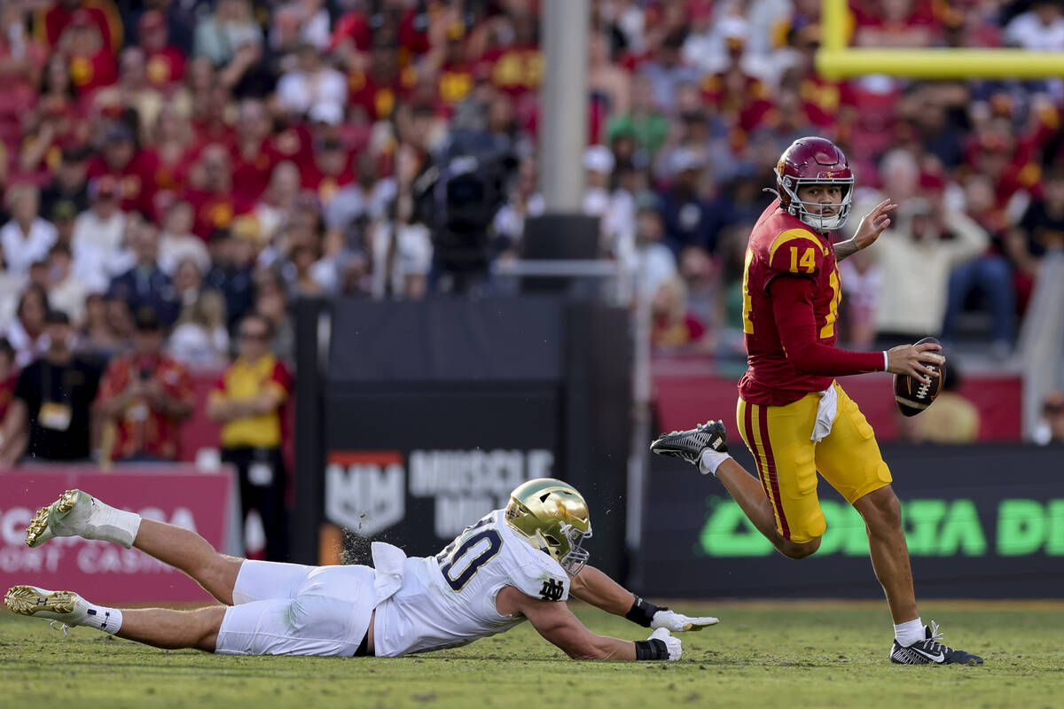 Southern California quarterback Jayden Maiava, right, runs past Notre Dame defensive lineman Lo ...