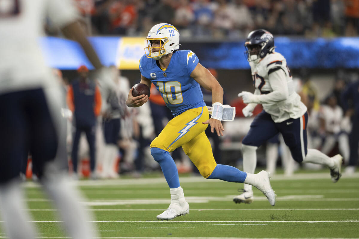 Los Angeles Chargers quarterback Justin Herbert (10) runs with the ball during an NFL football ...