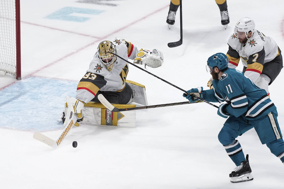 Vegas Golden Knights goaltender Adin Hill, left, stops the shot by San Jose Sharks center Luke ...