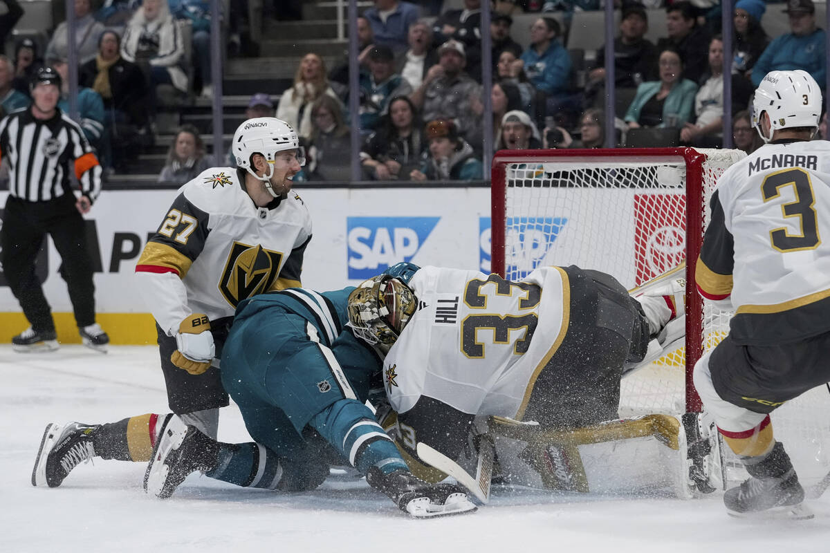 San Jose Sharks center Nico Sturm, second from left, collides with Vegas Golden Knights goalten ...