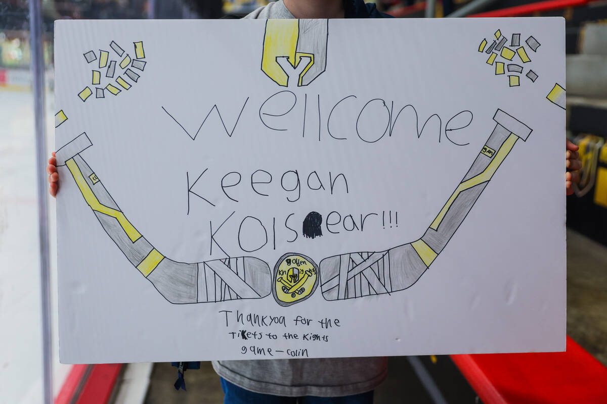 Colin Howlett, 11, holds up a sign that he made for Keegan Kolesar while sitting in on a Golden ...