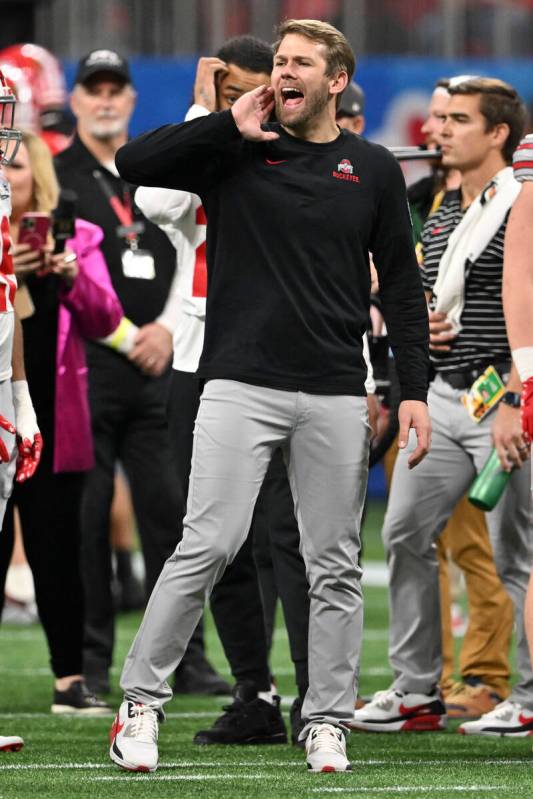 Ohio State quarterback's coach Corey Dennis speaks on the turf before the Peach Bowl NCAA colle ...