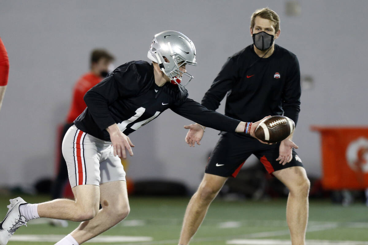 Ohio State quarterback Kyle McCord runs through a drill in front of quarterbacks coach Corey De ...