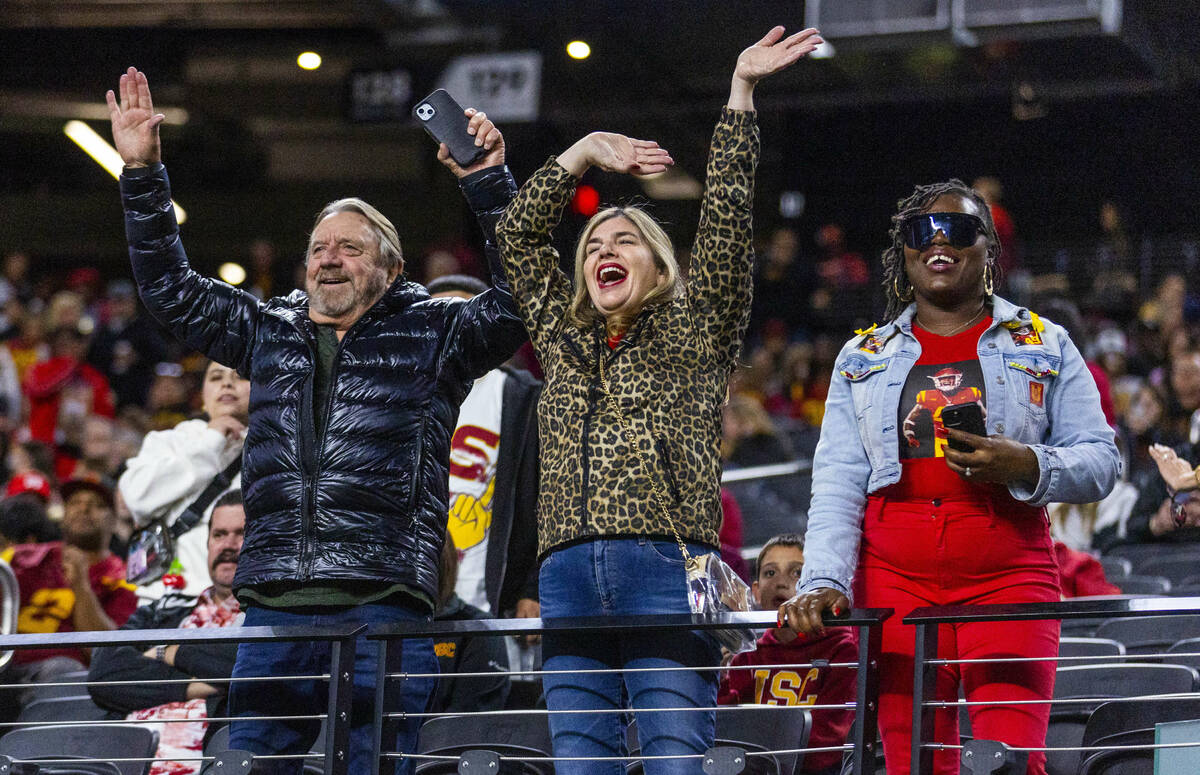 Family members wave to USC Trojans players taking the field as they warm up to face the Texas A ...