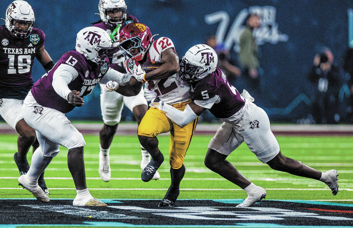 USC Trojans running back A'Marion Peterson (22) fights for more yards as Texas A&M Aggies d ...