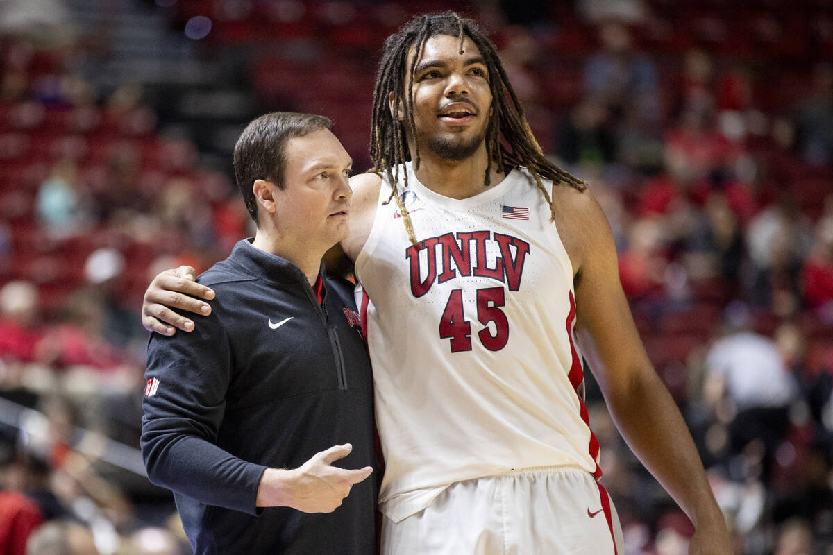 UNLV head coach Kevin Kruger and forward Jeremiah Cherry (45) hug during the college basketball ...