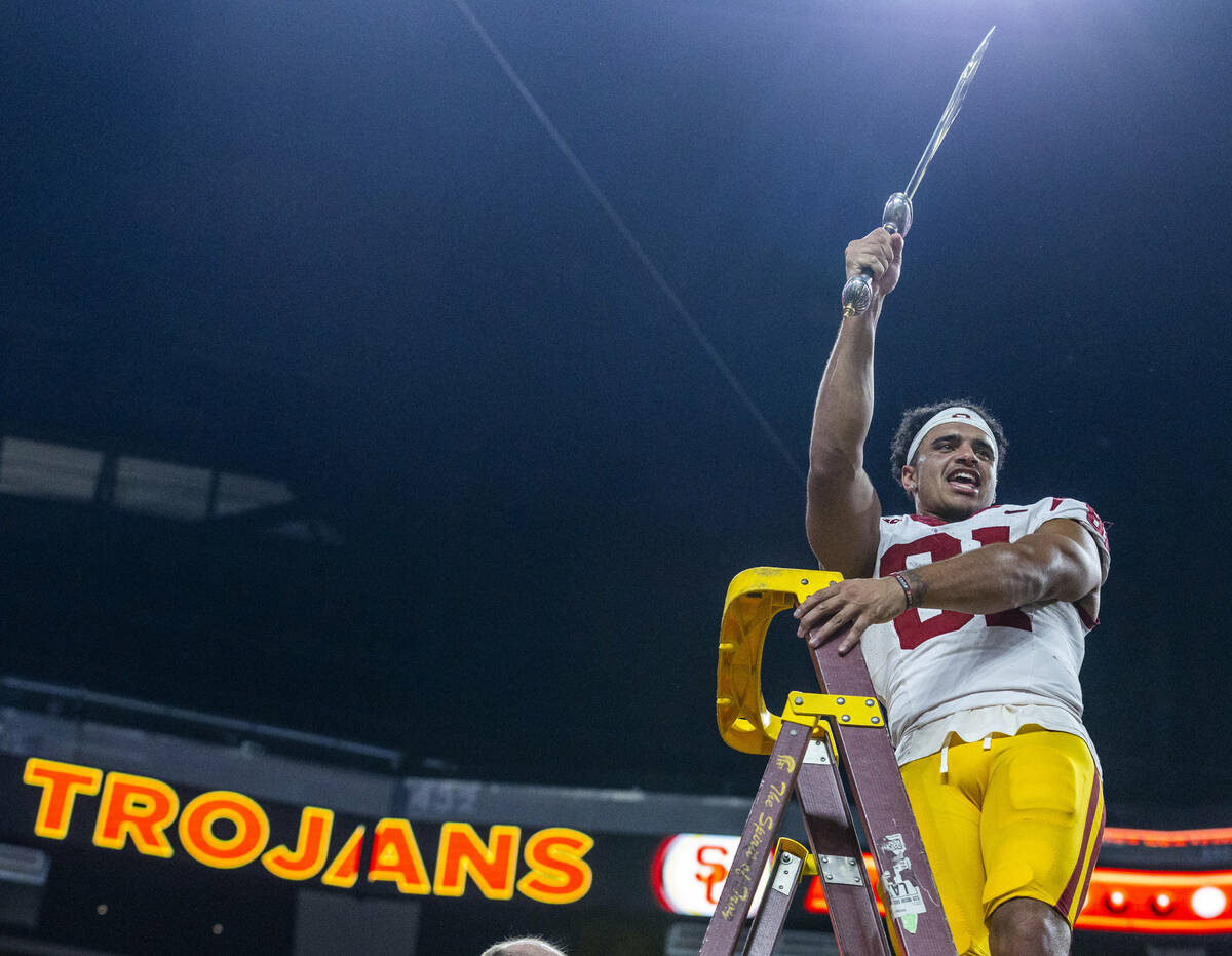 USC Trojans wide receiver Kyle Ford (81) holds up a sword as the celebrate their win over the ...