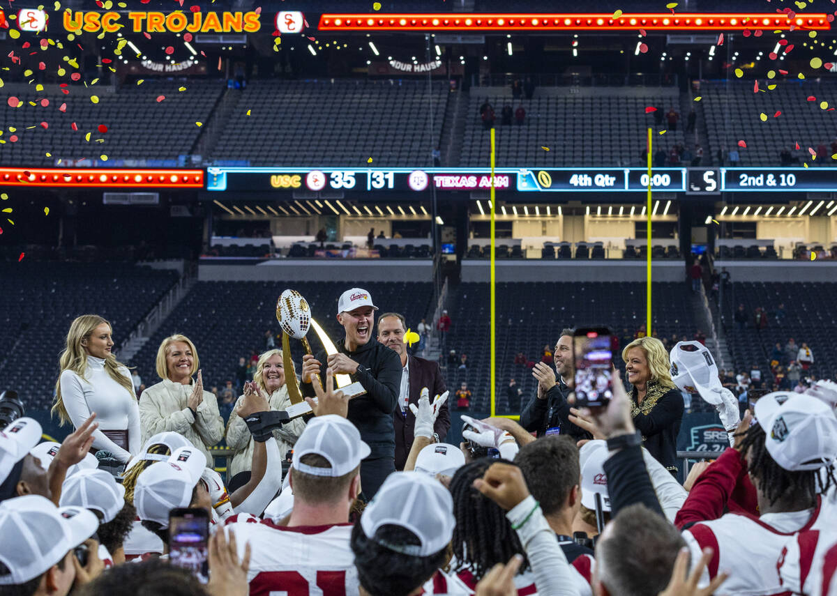 USC Trojans head coach Lincoln Riley holds the trophy as the celebrate their win over the Texas ...