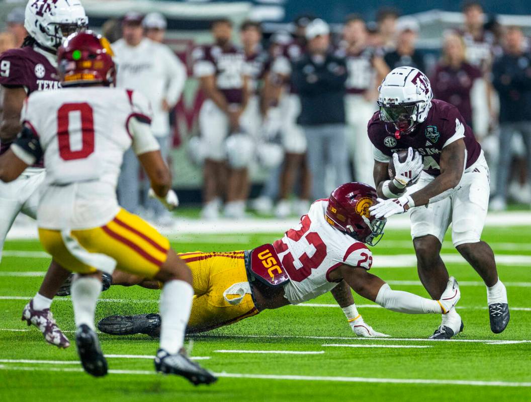 USC Trojans linebacker Desman Stephens II (23) grabs for the leg of Texas A&M Aggies wide r ...