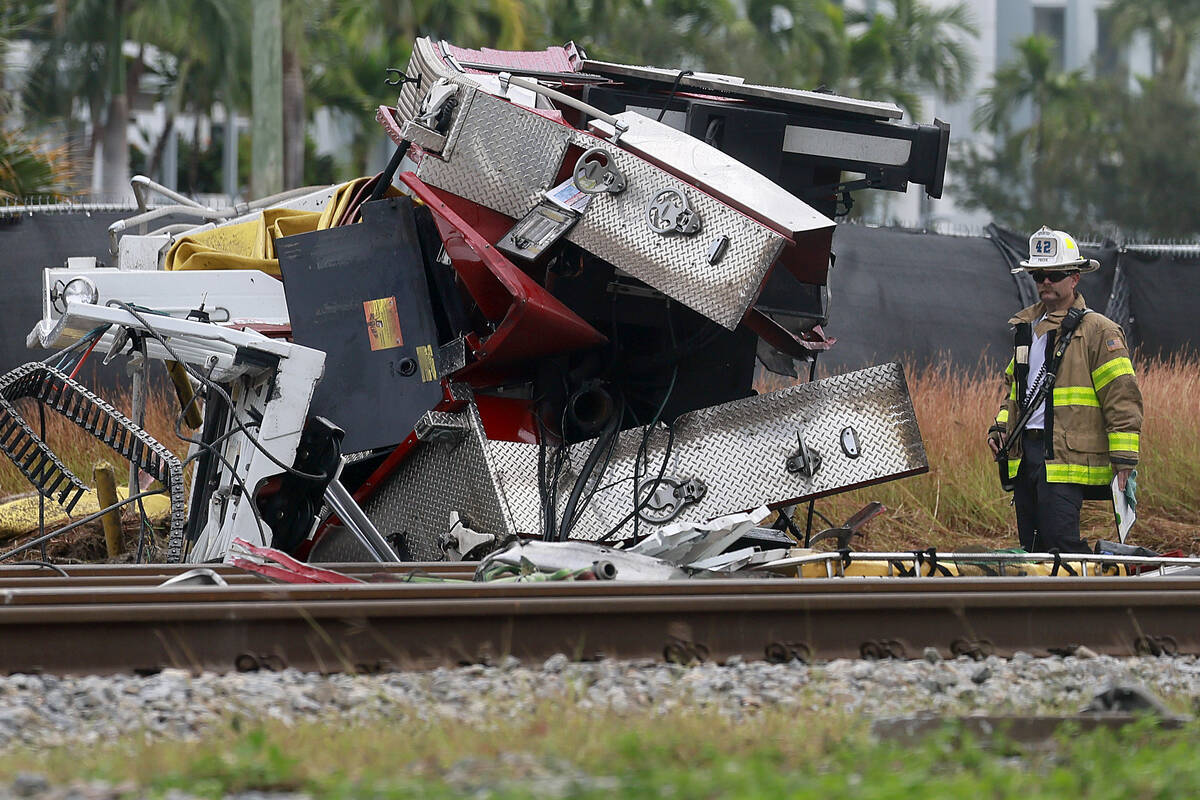 A fireman views damage after a Brightline train collided with a fire truck in downtown Delray B ...