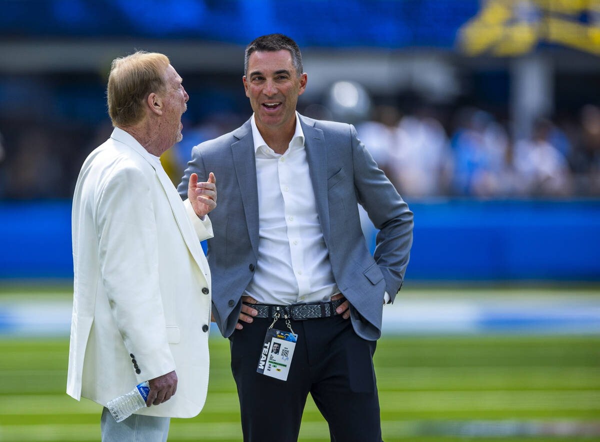 Raiders owner Mark Davis talks with general manage Tom Telesco on the sidelines before the firs ...