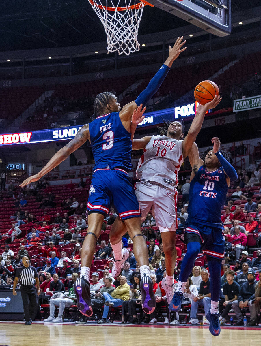 UNLV guard Jaden Henley (10) battles for a shot between Fresno State Bulldogs forward Elijah Pr ...