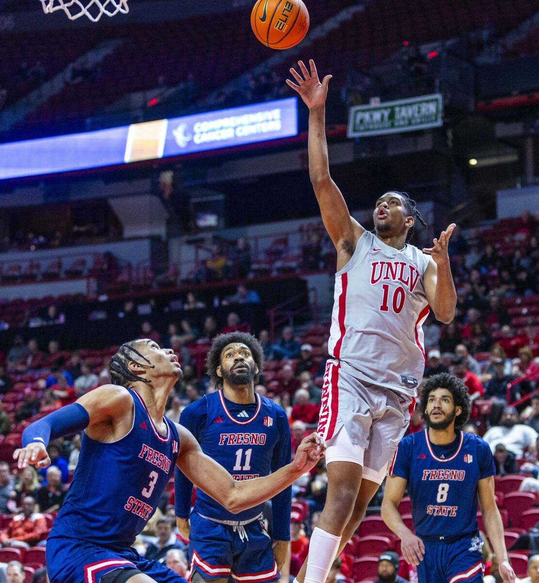 UNLV guard Jaden Henley (10)gets off a shot over Fresno State Bulldogs forward Elijah Price (3) ...