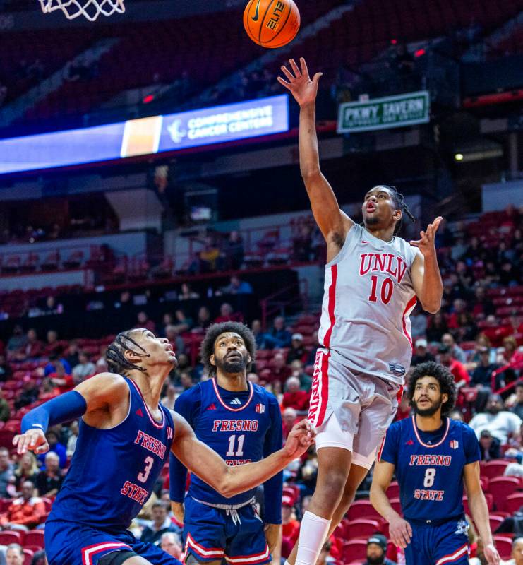 UNLV guard Jaden Henley (10)gets off a shot over Fresno State Bulldogs forward Elijah Price (3) ...