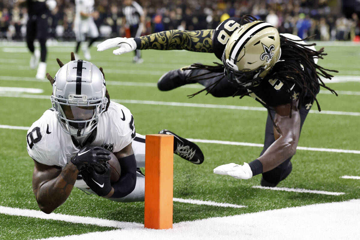 New Orleans Saints linebacker Demario Davis, right, tackles Las Vegas Raiders running back Amee ...