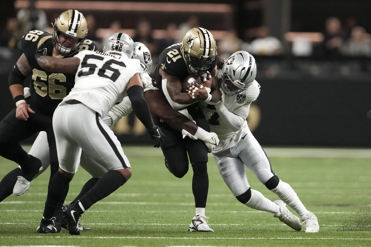 New Orleans Saints running back Jamaal Williams (21) is tackled by Las Vegas Raiders safety Tre ...