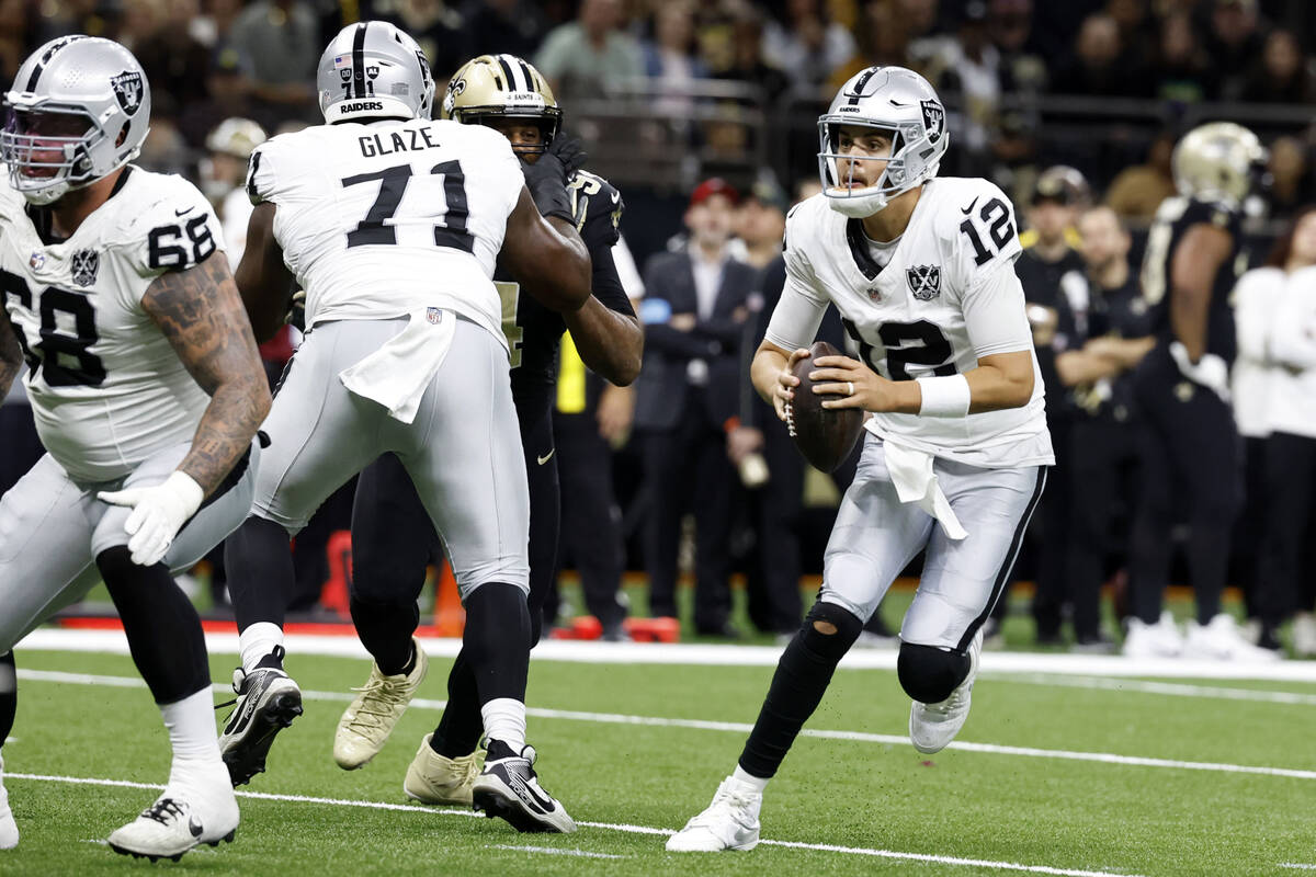 Las Vegas Raiders quarterback Aidan O'Connell (12) scrambles up field during the first half of ...