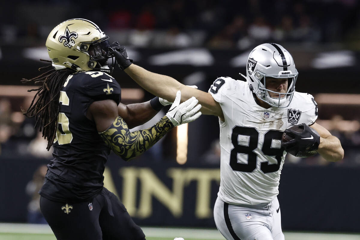 Las Vegas Raiders tight end Brock Bowers (89) runs from New Orleans Saints linebacker Demario D ...