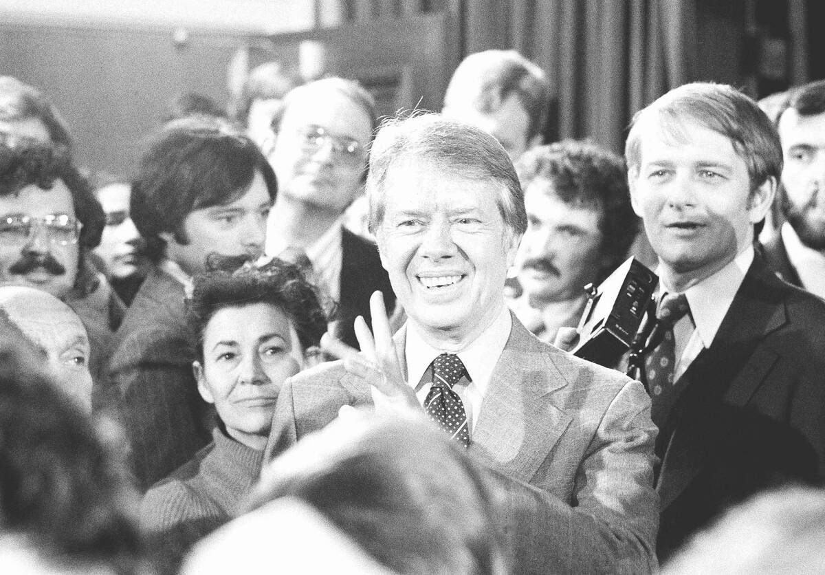 FILE - President Jimmy Carter, center, talks with reporters following his broadcast new confere ...