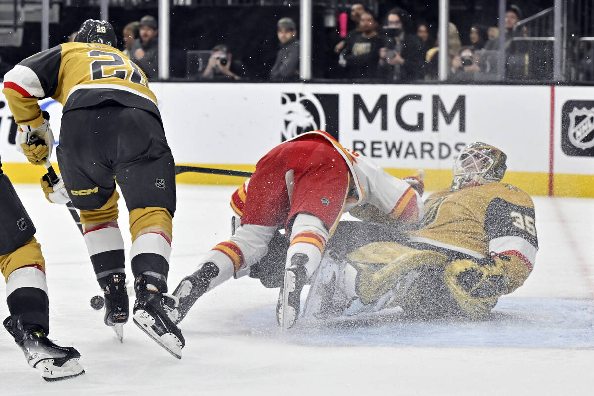 Calgary Flames left wing Ryan Lomberg, center, collides with Vegas Golden Knights goaltender Il ...