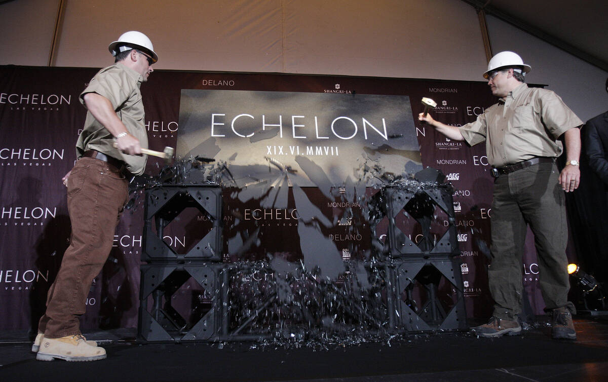 Echelon executives Bob Marra, left, and Ron Frye, use hammers to break a sheet of glass to reve ...