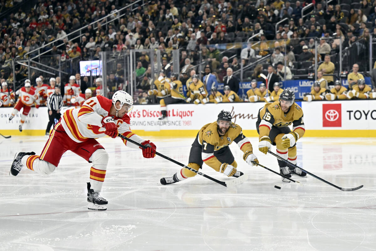 Calgary Flames center Mikael Backlund (11) takes a shot against Vegas Golden Knights defenseman ...