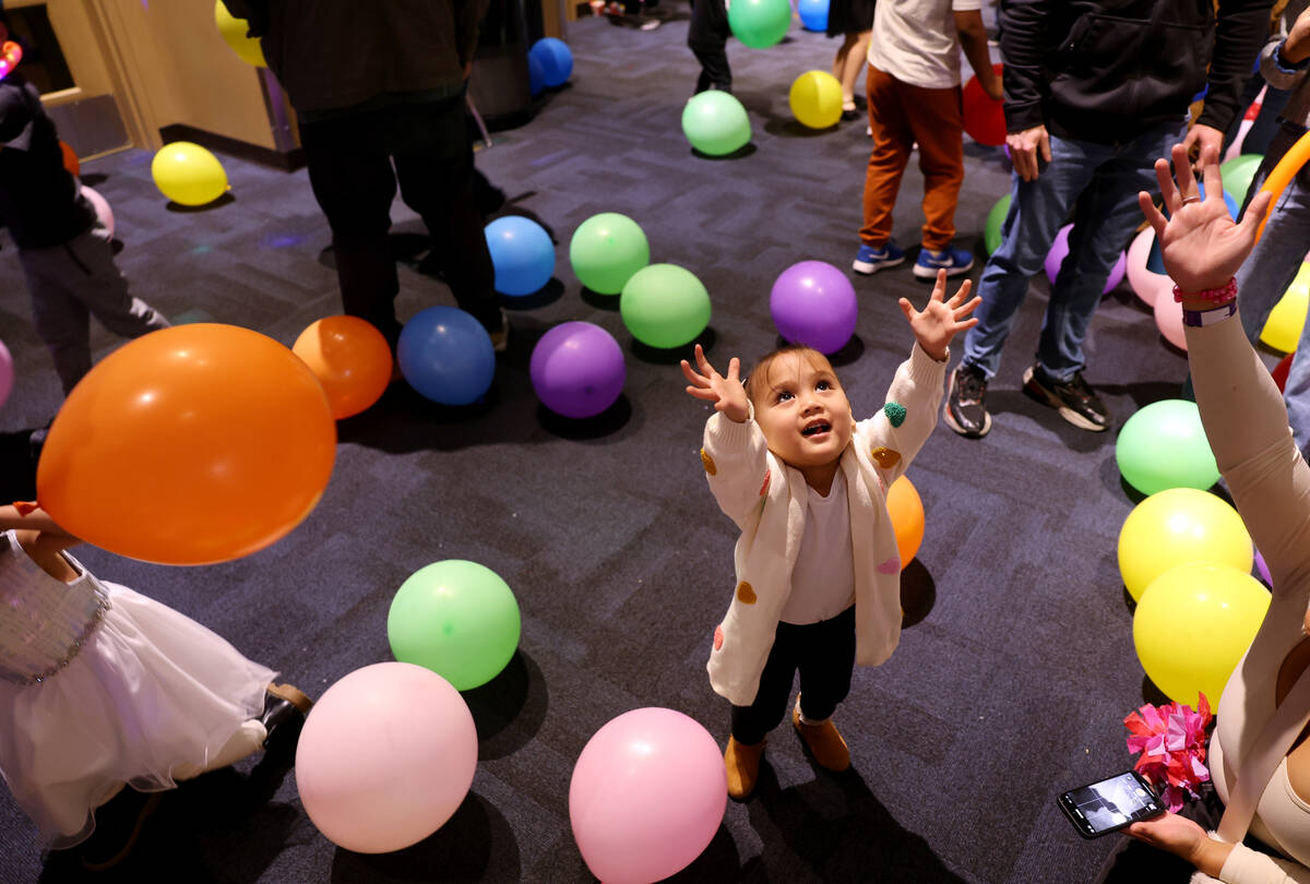 Children and their families celebrate under a balloon drop during “Noon Year’s Ev ...