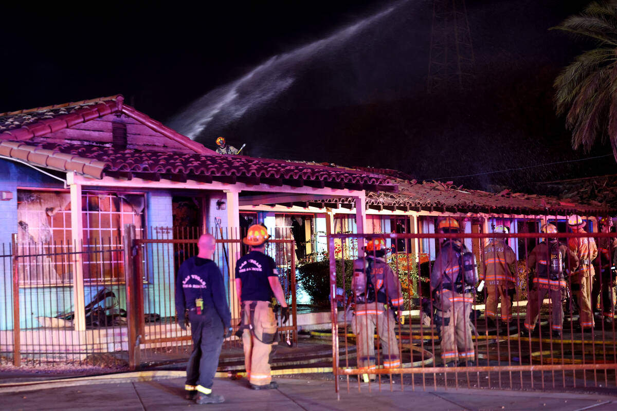 Las Vegas firefighters work a fire at the former Lucky Motel on East Fremont Street in downtown ...