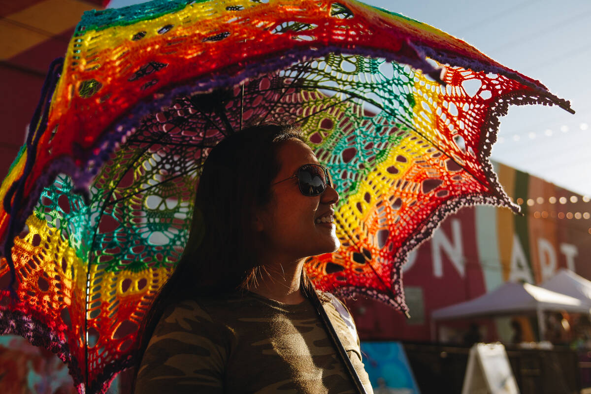 Elaine Ferraro blocks out the sun with an umbrella made by Ama Trussell, a local artist who sel ...