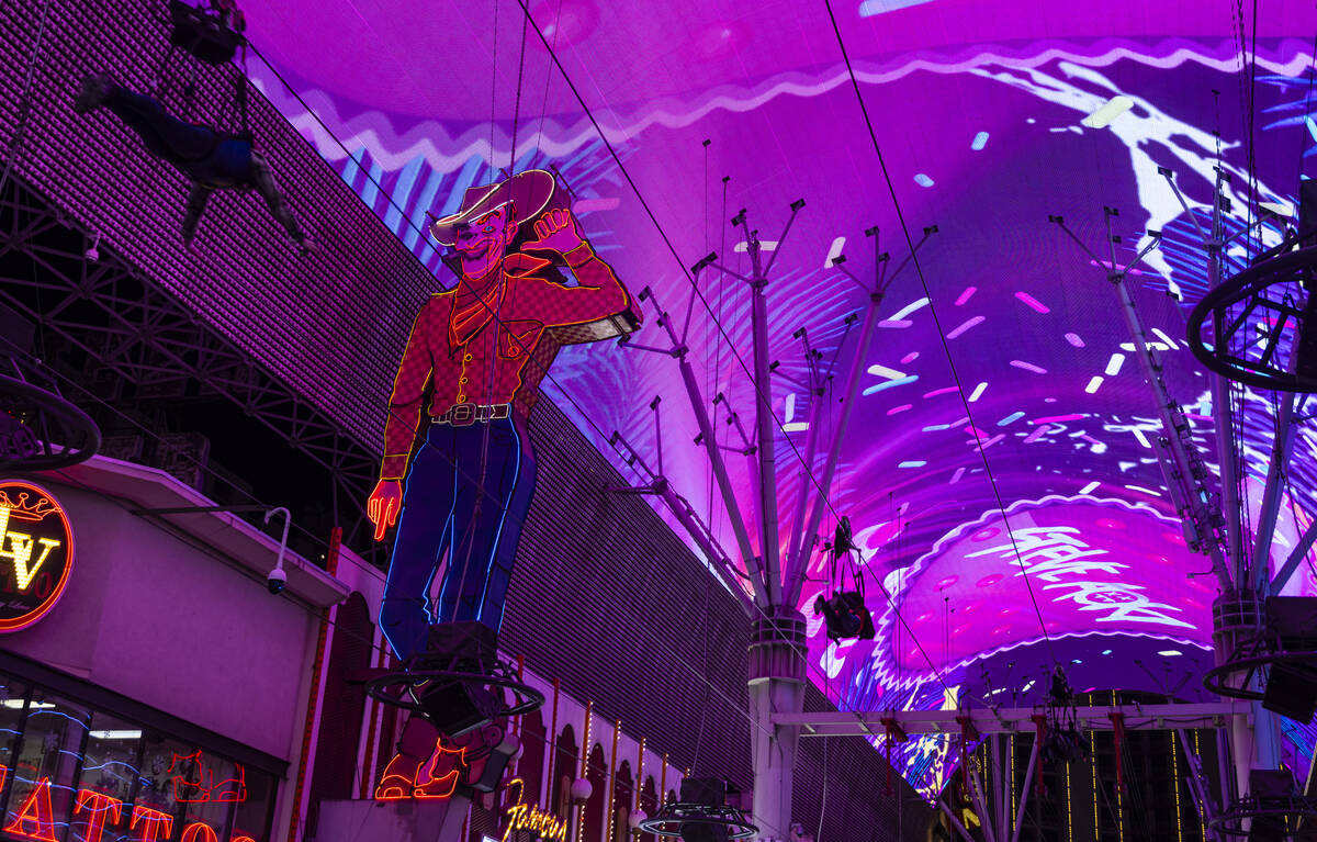 People take the Slotzilla zipline past Vegas Vic along the Fremont Street Experience on Wednesd ...