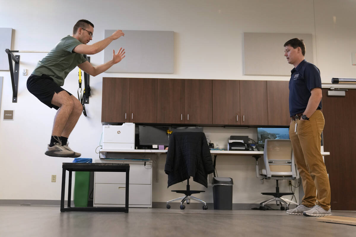 Physical therapist Tyler Detmer, right, works with patient Jacob Bullard at WashU, Monday, Dec. ...