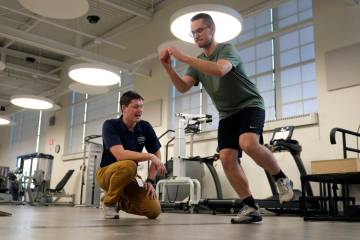 Physical therapist Tyler Detmer, left, works with patient Jacob Bullard at WashU, Monday, Dec. ...