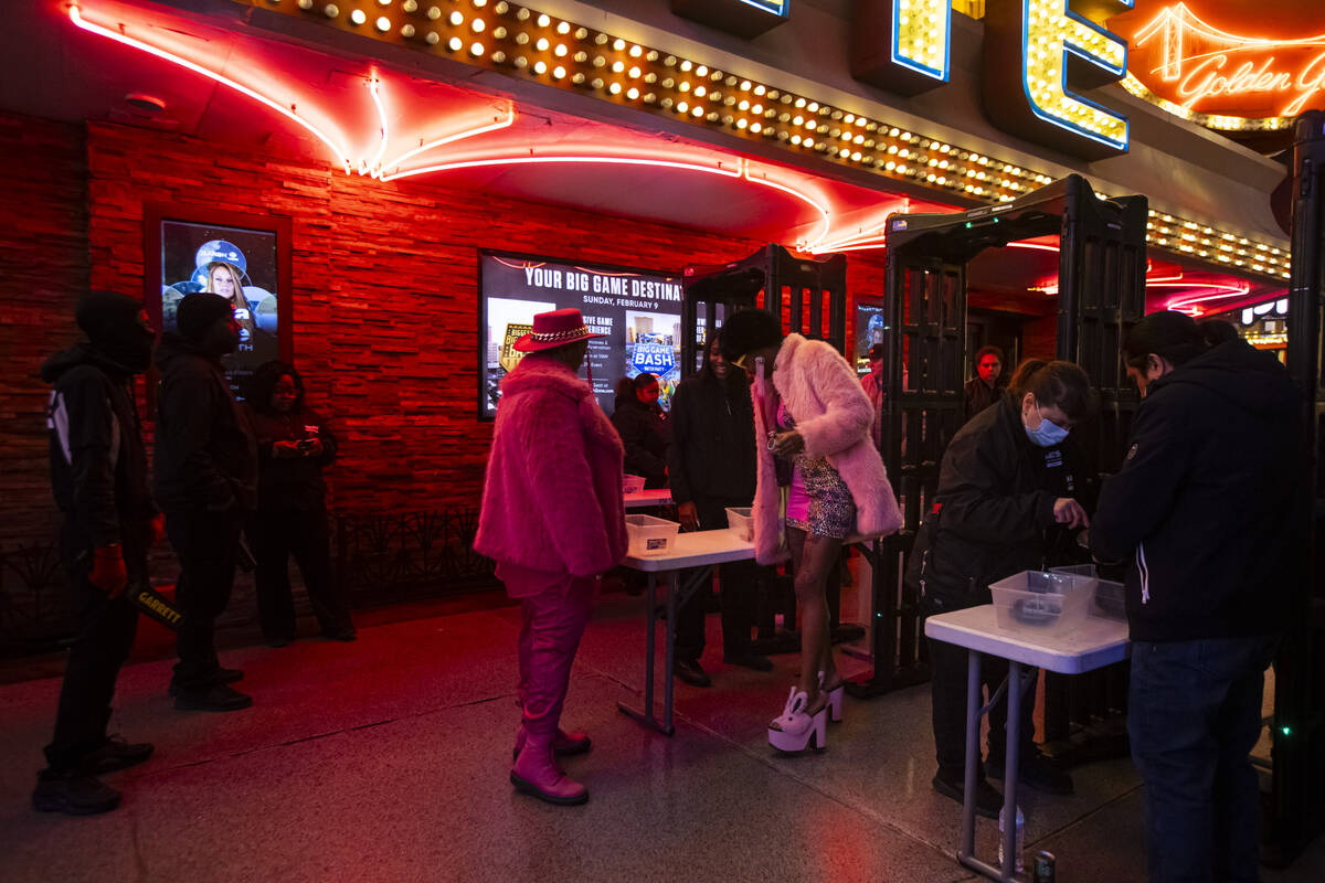 New Year's Eve revelers make their way through security at the Fremont Street Experience Tuesda ...