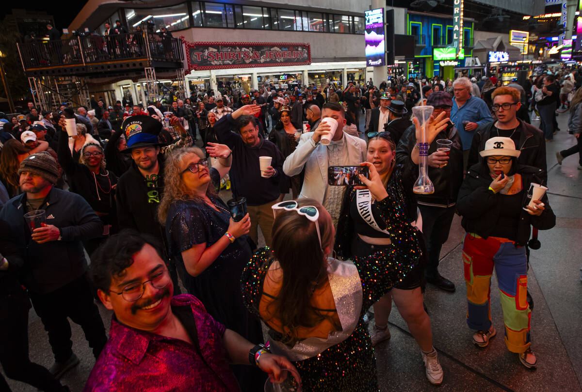 People pose for photos during the New Year’s Eve celebration at the Fremont Street Exper ...