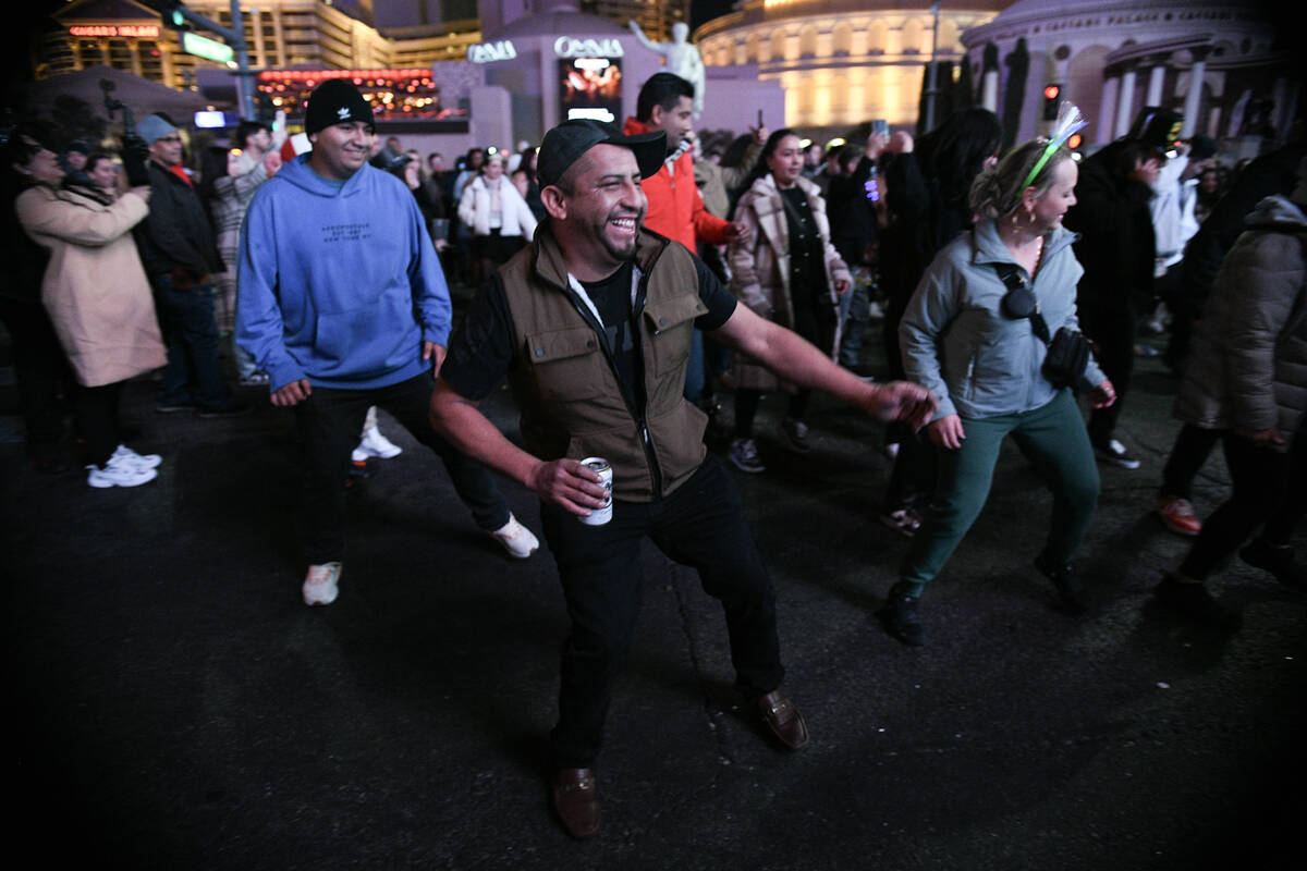 Revelers take part in an impromptu New Year’s Eve line dance on the Strip Wednesday, Jan ...