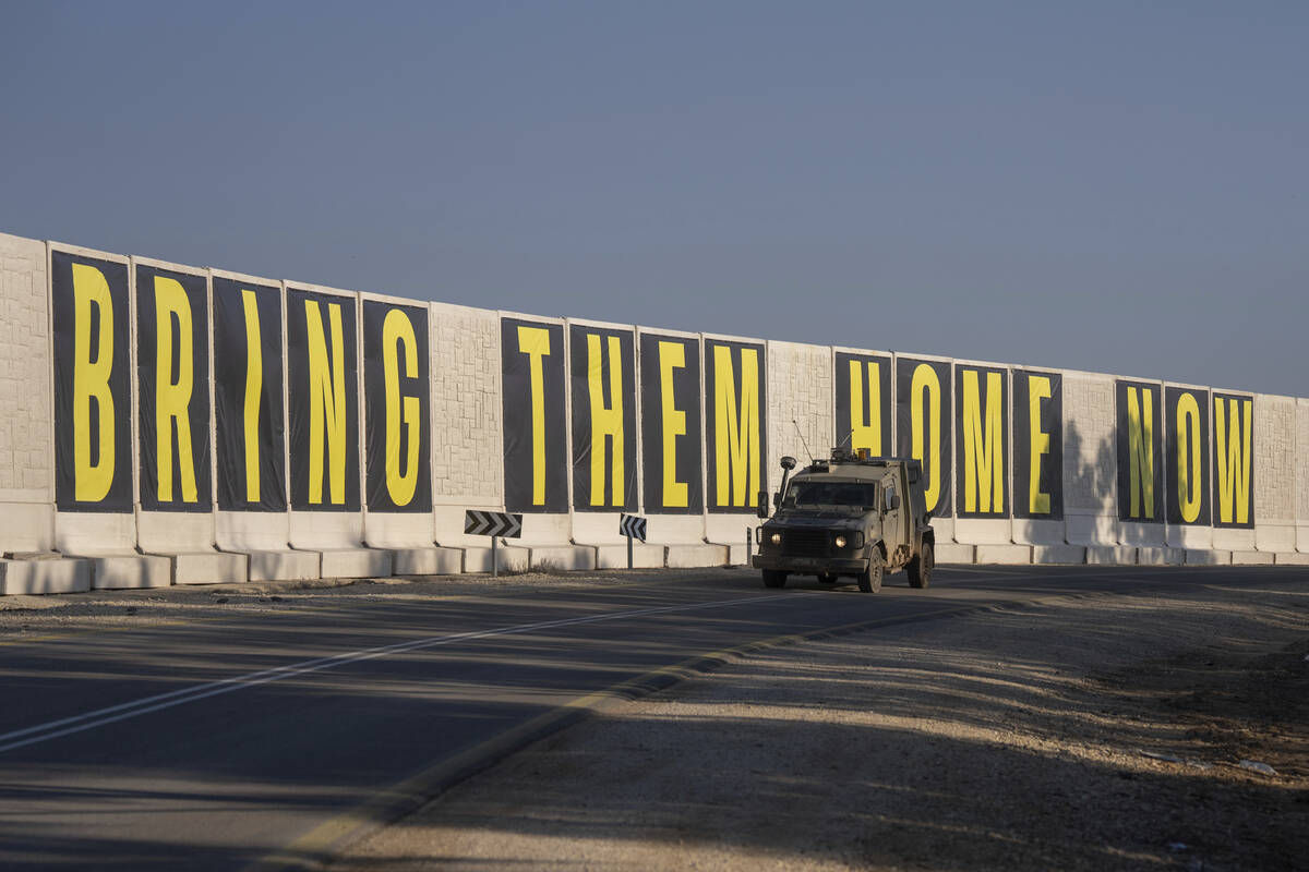 An israeli army vehicle near the Israeli-Gaza border, drives beside a banner reading " Bri ...