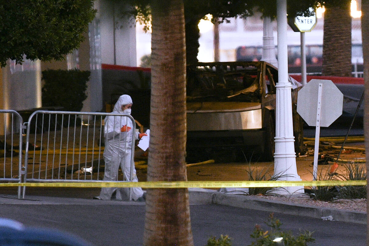 A worker in a hazmat suit walks past a Tesla Cybertruck after it exploded outside Trump Interna ...