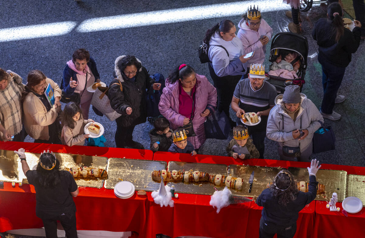 People wait in line to get a slice of the Rosca de Reyes (King’s Cake) and hopefully find a h ...