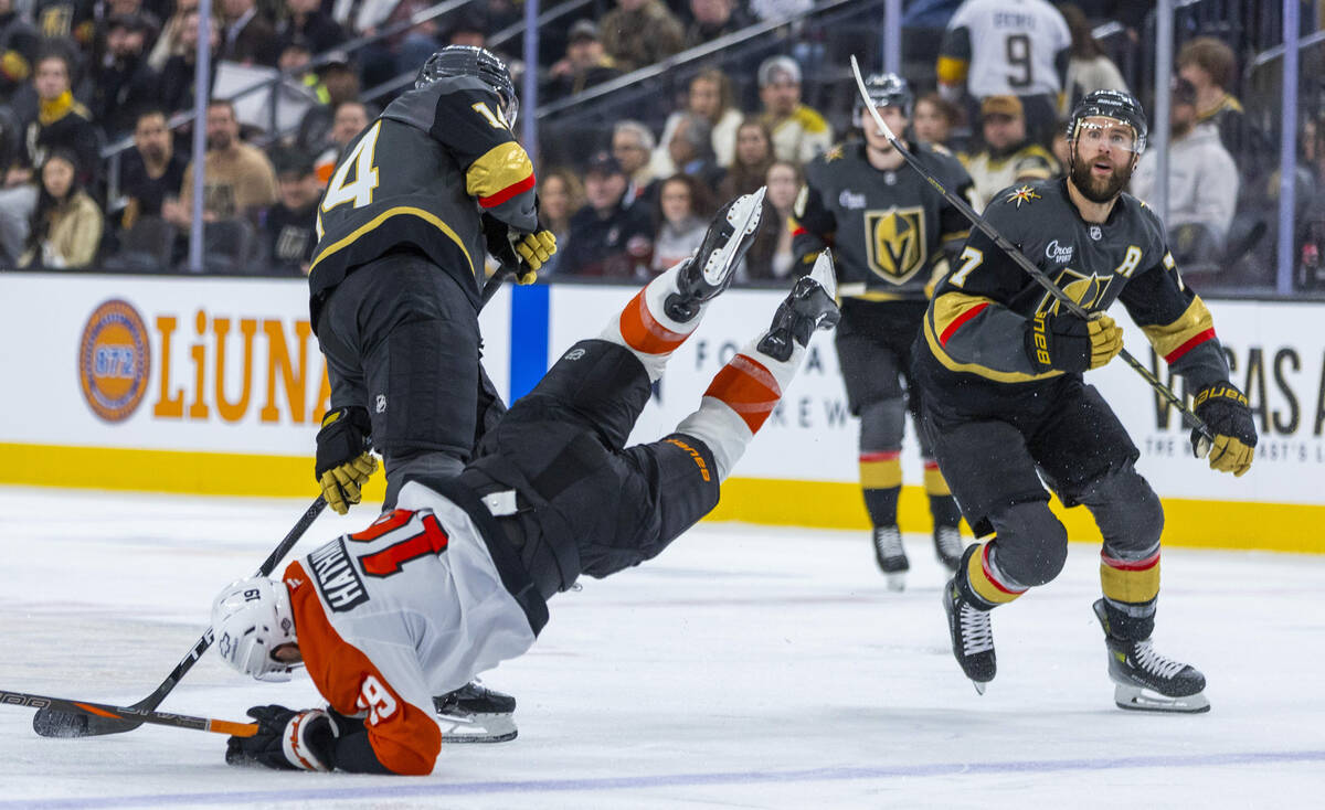 Golden Knights defenseman Nicolas Hague (14) upends Philadelphia Flyers right wing Garnet Hatha ...