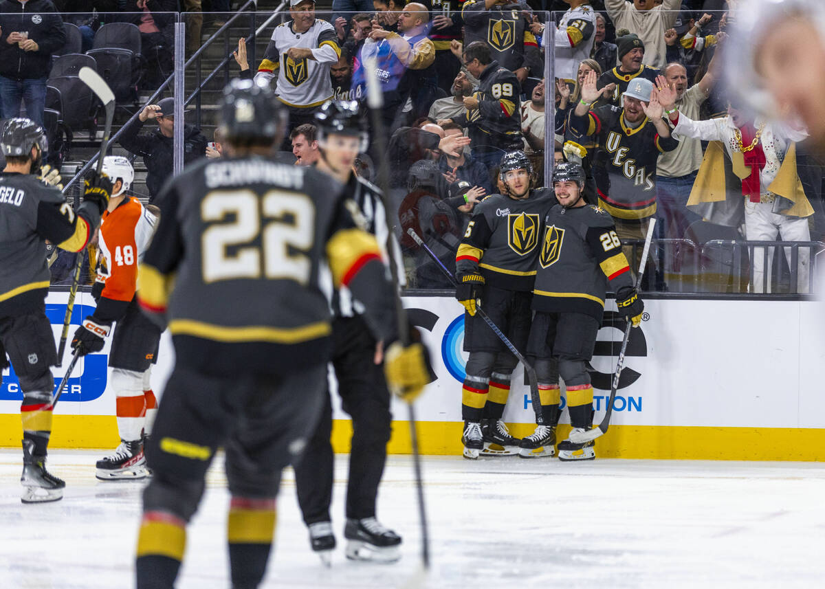 Golden Knights defenseman Noah Hanifin (15) and Golden Knights right wing Alexander Holtz (26) ...