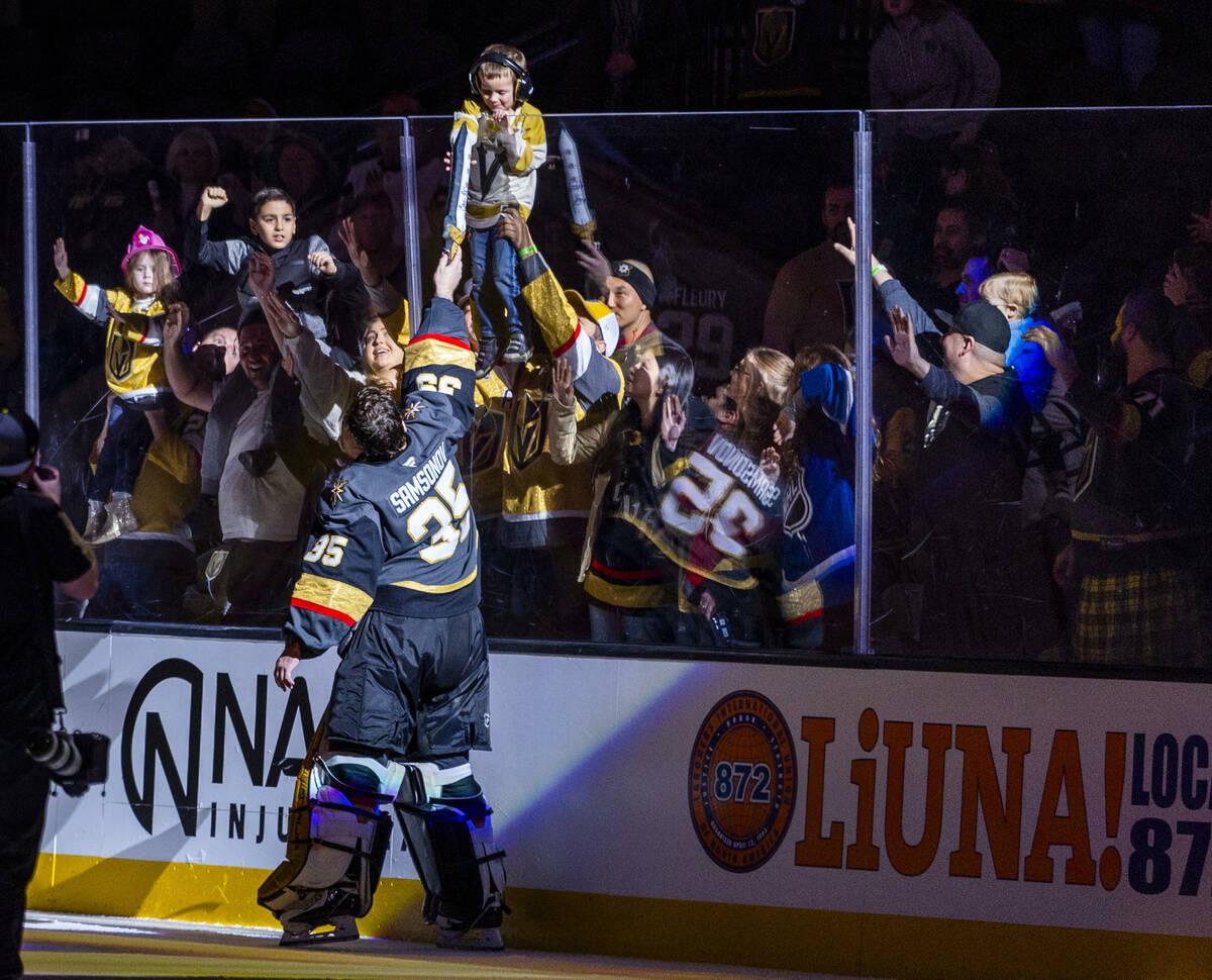 Golden Knights goaltender Ilya Samsonov (35) awards a toy sword to a fan as player of the game ...