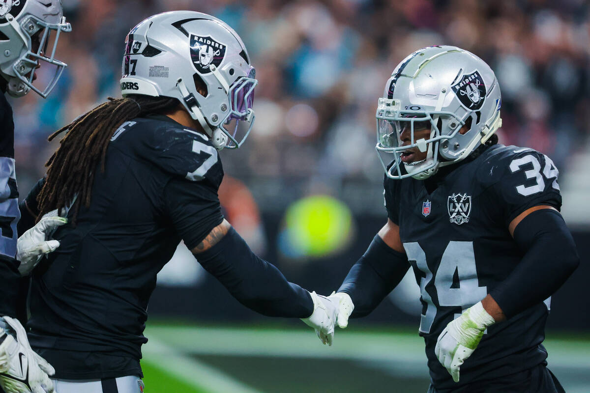 Raiders safety Thomas Harper (34) and safety Tre'von Moehrig (7) celebrate during an NFL footba ...